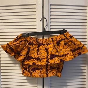 Ofuure crop top with puffed sleeves graphic print in red and orange.